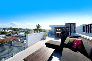 a balcony with a bench and a table on a roof at Wanderlust in Gold Coast