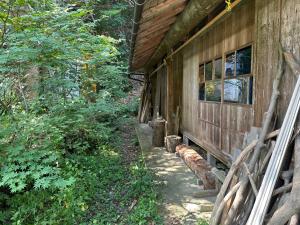 a side of a house with a bench next to it at 木古里ゲストハウス Kicoli guesthouse in Chizu