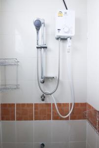 y baño con ducha y cabezal de ducha. en SCN City Hotel Rayong, en Ban Chang