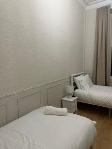 a bedroom with two beds and a lamp on a table at Modern Twin Room In The Heart Of Edinburgh in Edinburgh +3 photos