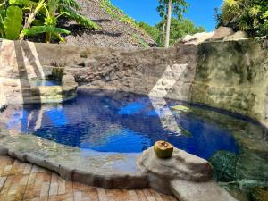 a large pool of water with a stone wall at Rote Surf Resort - Lualemba Bungalows in Nembrala
