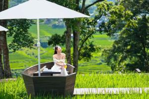 a statue of a woman in a bath tub with an umbrella at MT House With Mountain View - Sa Pa Trekking Tour in Sa Pa