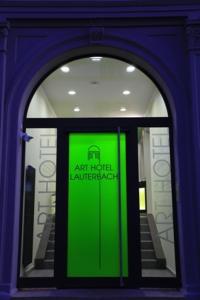 una puerta con una señal verde frente a un edificio en Art Hotel Lauterbach, en Kaiserslautern
