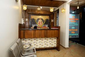 a restaurant with two chairs in front of a counter at Sai Vishwakarma Palace in Shirdi