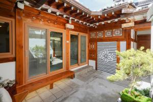 un porche de una casa con paredes y ventanas de madera en Seoul premium hanok StayDalmaji, en Seúl