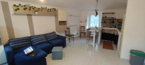 a living room with a blue couch and a kitchen at Cascina Babi in San Giuliano