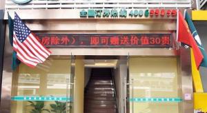 an entrance to a building with an american flag at GreenTree Inn Shanghai South Railway Station Xujiahui Stadium Subway Station Shell Hotel in Shanghai