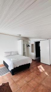 a bedroom with a bed in a white room at Happy Forest B&B in Katima Mulilo