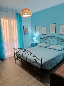 a bedroom with a bed with a blue wall at Casa Azzurra in Giardini Naxos
