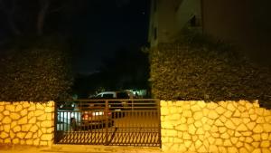 een poort naar een oprit 's nachts met een auto bij Apartment House Nono in Povljana