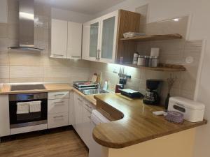 a kitchen with white cabinets and a wooden counter top at EDI APP Bovec Center-Free Parking & Mountain View in Bovec