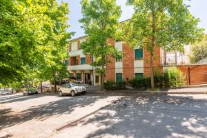 an apartment building with a car parked in front of it at Appartamento Comfort alle Terme in Chianciano Terme