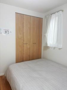 Postel nebo postele na pokoji v ubytování 鎌倉楠Home
