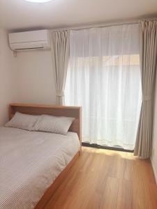 Postel nebo postele na pokoji v ubytování 鎌倉楠Home