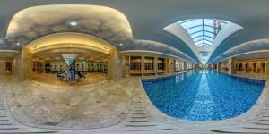 a large swimming pool in a building with a glass ceiling at Holiday Inn Guangzhou Airport Zone By IHG in Huadu