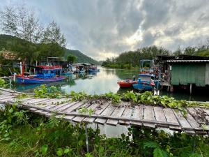 a group of boats are docked on a river at The Summer Guesthouse in Ban Khlong Son