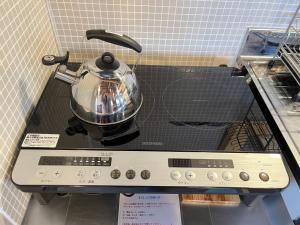 a tea kettle sitting on top of a stove at 城下町小諸の古民家 - 町屋の隠れ宿-椛庵 Japanese old folk house - momijian in Komoro +16 photos