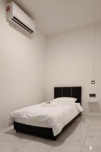 a white bedroom with a bed and a air conditioner at 23 Inn Singlebed Share Bathroom No Window in Bukit Mertajam
