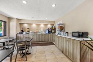 Un restaurante con mesas y sillas y un mostrador. en Super 8 by Wyndham Elgin, en Elgin