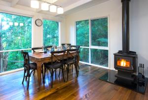 - une salle à manger avec une table et un poêle à bois dans l'établissement Belle Cottage Secluded Stay Near Shops Cafes, à Sassafras