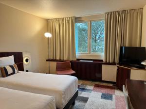 Una habitación de hotel con dos camas y un televisor. en Mercure Besancon Parc Micaud - Hotel & Bar, en Besançon 22 fotos más