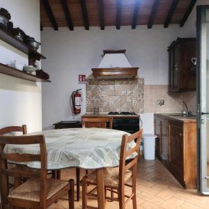 y cocina con mesa, sillas y fogones. en Agriturismo Raggio di Sole, en Montepulciano