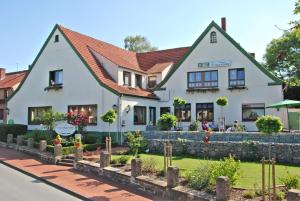 ein weißes Gebäude mit rotem Dach in der Unterkunft Hotel Pension Haus Stork in Holzhausen