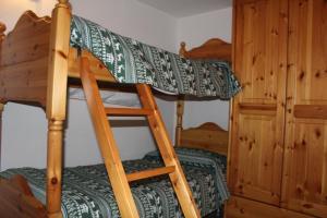 a bunk bed with a ladder in a room at In perfetto stile valdostano in Saint Vincent