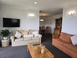 a living room with a couch and chessboard on a table at Fitzroy Holiday Home ideal for Groups and Families in New Plymouth