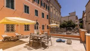 a patio with a table and an umbrella and chairs at Villa Catania in Mali Lošinj