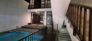 a house with a swimming pool and a staircase at Serenity Nirvana Palace- Pool, Kichen, Deluxe & Dorm Rooms Near Uluwatu in Jimbaran +13 photos
