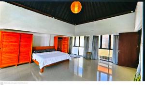 a bedroom with a bed and some windows at Serenity Nirvana Palace- Pool, Kichen, Deluxe & Dorm Rooms Near Uluwatu in Jimbaran