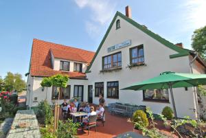 a group of people sitting at a table in front of a building at Hotel Pension Haus Stork in Holzhausen