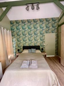 Les ChampeauxにあるVilla été , chalet hiver près de Camembert avec jacuzzi et piscine chauffée 15 avril au 1er octobreのベッドとタオル2枚のある寝室