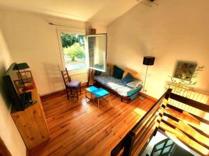a living room with a couch and a window at Charming brickyard cottage near a lock in Ayguesvives