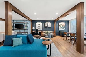 a living room with a blue couch and a dining room at Everhome Suites Huntsville - Research Park in Huntsville