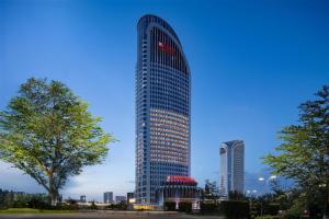 a tall building with a lot of windows at Hilton Garden Inn Urumqi Railway Station in Ürümqi