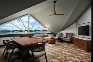 新伯尔尼Tryon Riverfront Inn New Bern, Tapestry Collection By Hilton的带桌椅和大窗户的客厅