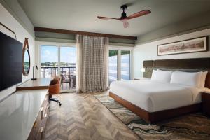 新伯尔尼Tryon Riverfront Inn New Bern, Tapestry Collection By Hilton的一间卧室，配有一张床、一张书桌和一扇窗户
