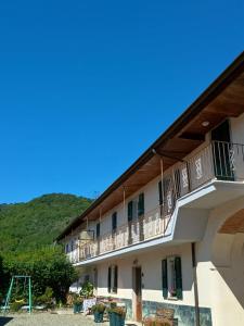 a building with a balcony with a hill in the background at Casa Vacanza Arzello in Melazzo +16 photos