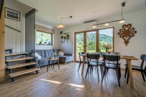 a living room with a couch and a table and chairs at Dunajec Spa House in Tylmanowa