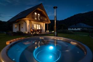 a hot tub in front of a house at night at Dunajec Spa House in Tylmanowa