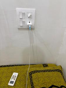 a remote control on a bed in a room at Shivaksh Rental Flats and Rooms- Best Hotel in Bhawani Mandi in Bhawāni Mandi