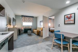 CoppellHome2 Suites by Hilton Coppell DFW Grapevine North的配有桌椅的厨房和客厅
