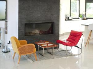 un salon avec deux chaises et une cheminée dans l'établissement Grande Villa 350 M2, piscine chauffée vue mer et collines, CAVALAIRE sur mer, 10 personnes, à Cavalaire-sur-Mer