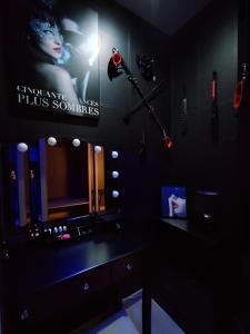 a dark room with a vanity with a light and a mirror at Love Room, Gîte 4 étoiles, 50 Nuances Romantiques in Villeneuve-en-Retz