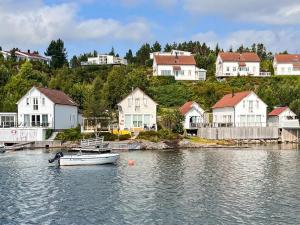 a small boat in the water in front of houses at 9 person holiday home in GURSKØY-By Traum in Kjellsund