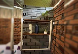 a room with a brick wall and shelves with plants at Phum Khnhom Bungalow in Battambang