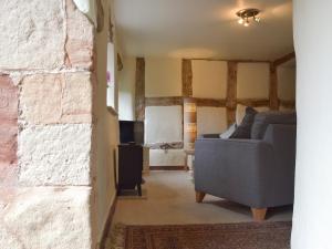 a living room with a couch and a brick wall at Jasmine Cottage - Uk4176 in Mayfield