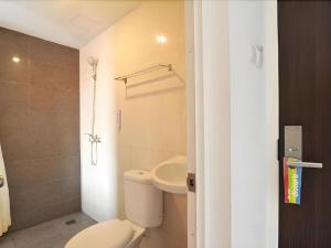 a bathroom with a white toilet and a sink at Guest House Nozz in Semarang +117 photos